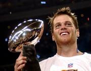 FILE - New England Patriots quarterback Tom Brady holds the Vince Lombardi Trophy after the Patriots beat the Carolina Panthers 32-29 in Super Bowl XXXVIII in Houston, Feb. 1, 2004. Tom Brady has retired after winning seven Super Bowls and setting numerous passing records in an unprecedented 22-year-career. He made the announcement, Tuesday, Feb. 1, 2022, in a long post on Instagram. (AP Photo/Dave Martin, File)