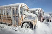 File photo of school buses covered with snow and ice.