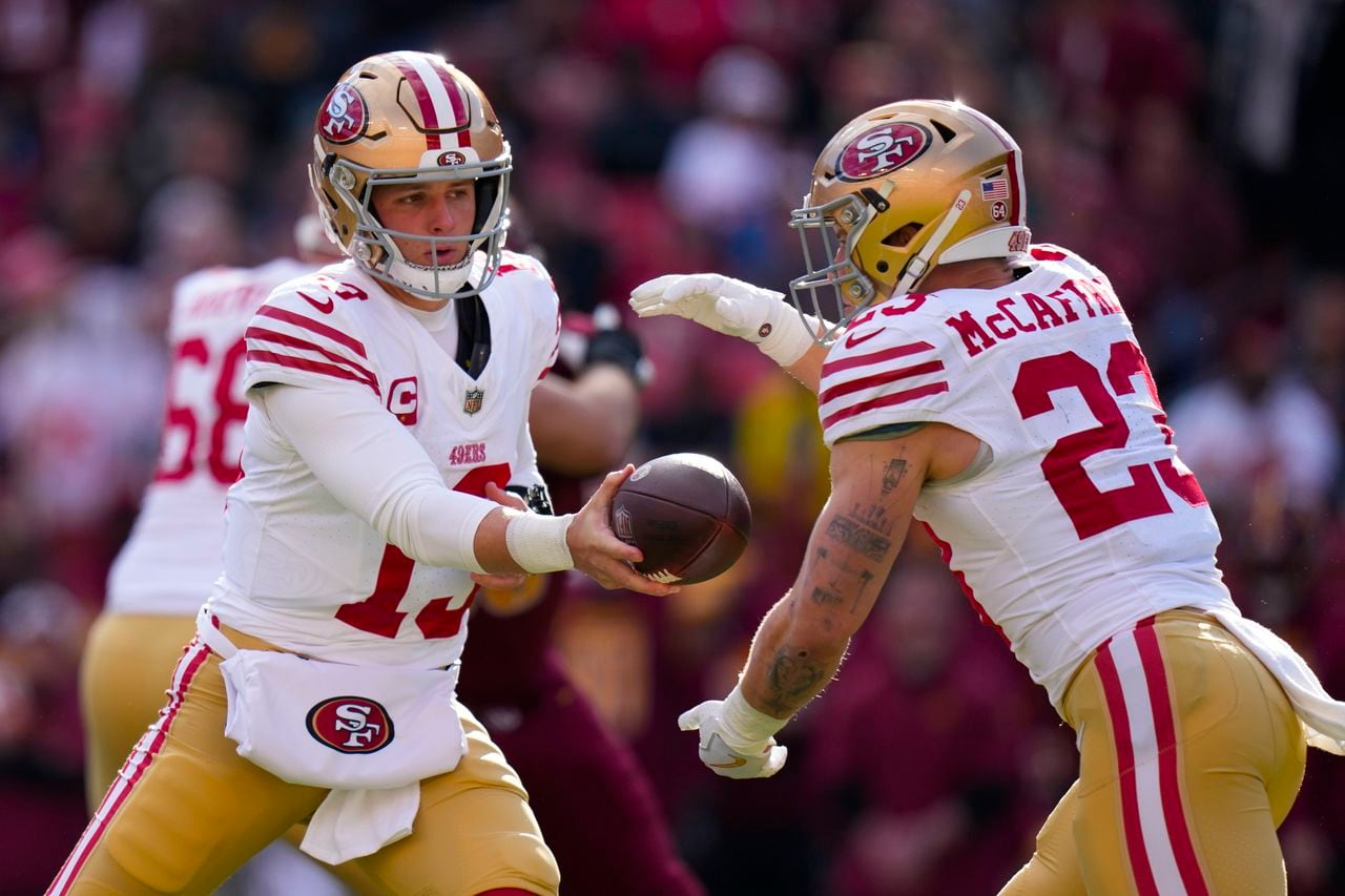 San Francisco 49ers quarterback Brock Purdy (13) hands the ball off to running back Christian McCaffrey (23) during the first half of an NFL football game